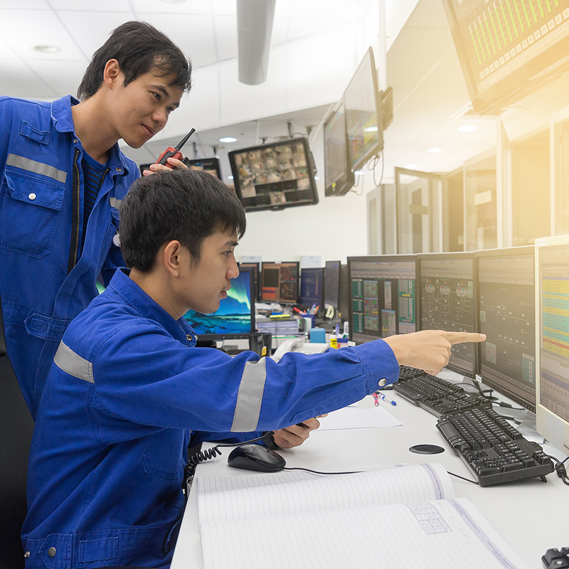 Picture of two men looking at a SCADA screen in a control room