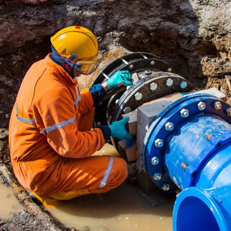 Image of worker fixing a leaking pipe